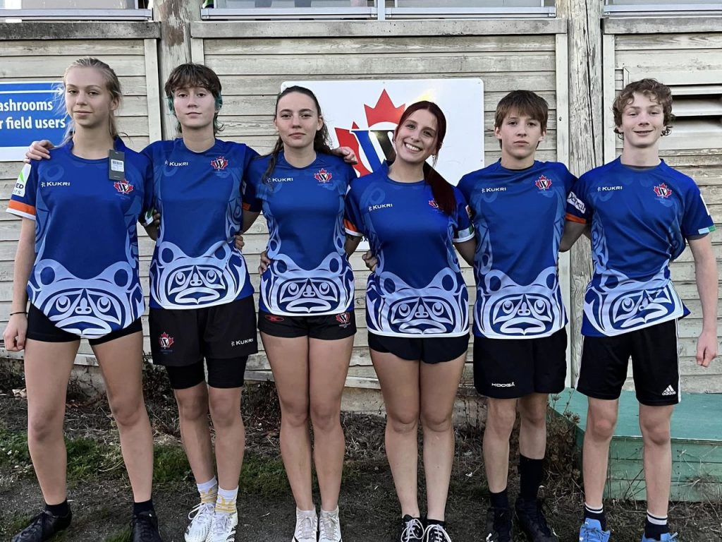 A group of Westshore juniors in blue swirl jerseys together after a game.