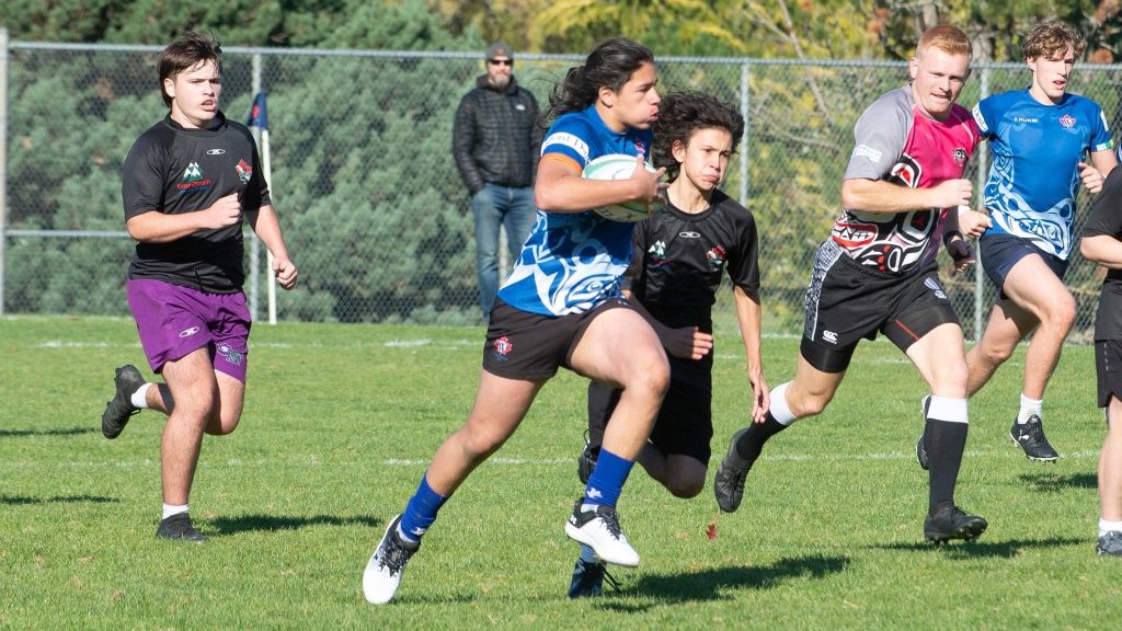Westshore junior players running with the ball on the pitch